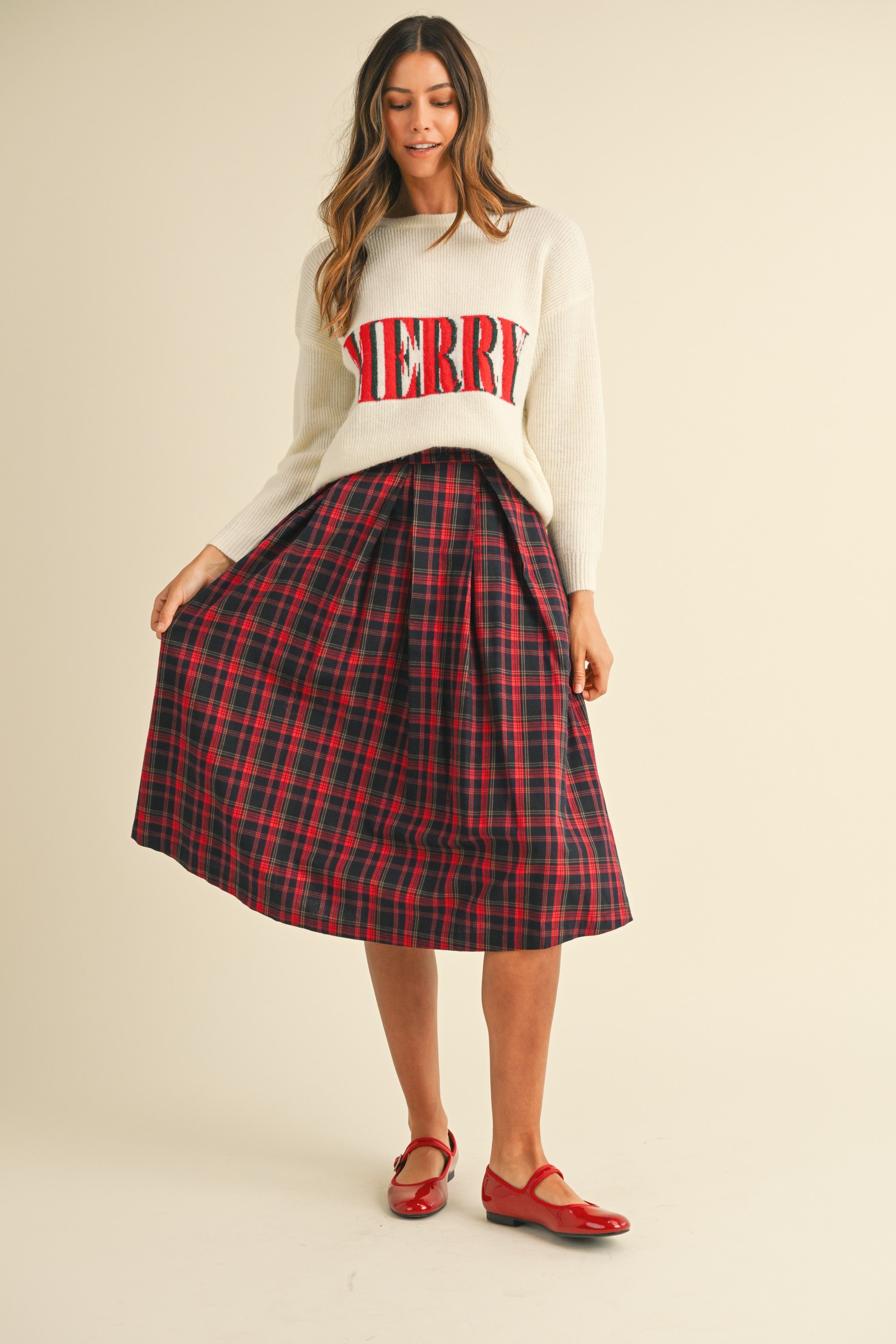 cream sweater with "merry" written on front in red