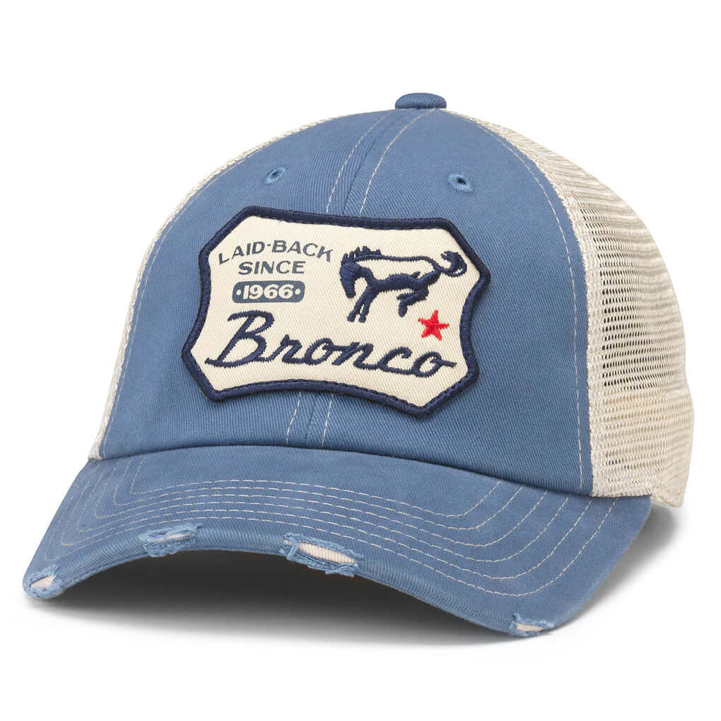 Light blue trucker hat with a patch on the front with a bucking bronco and words laid back since 1966 and a red star