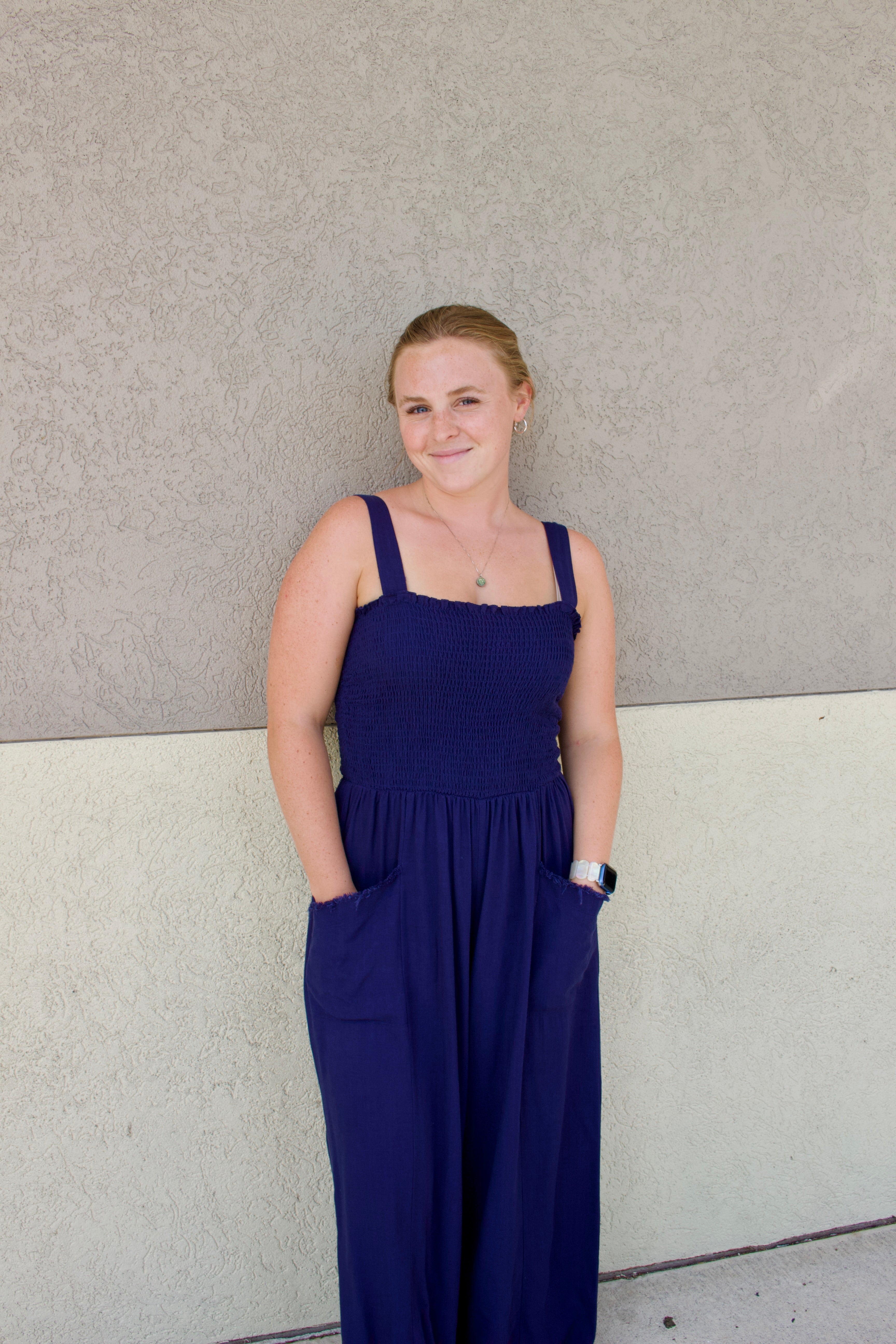blue jumpsuit with smocked top and front pockets