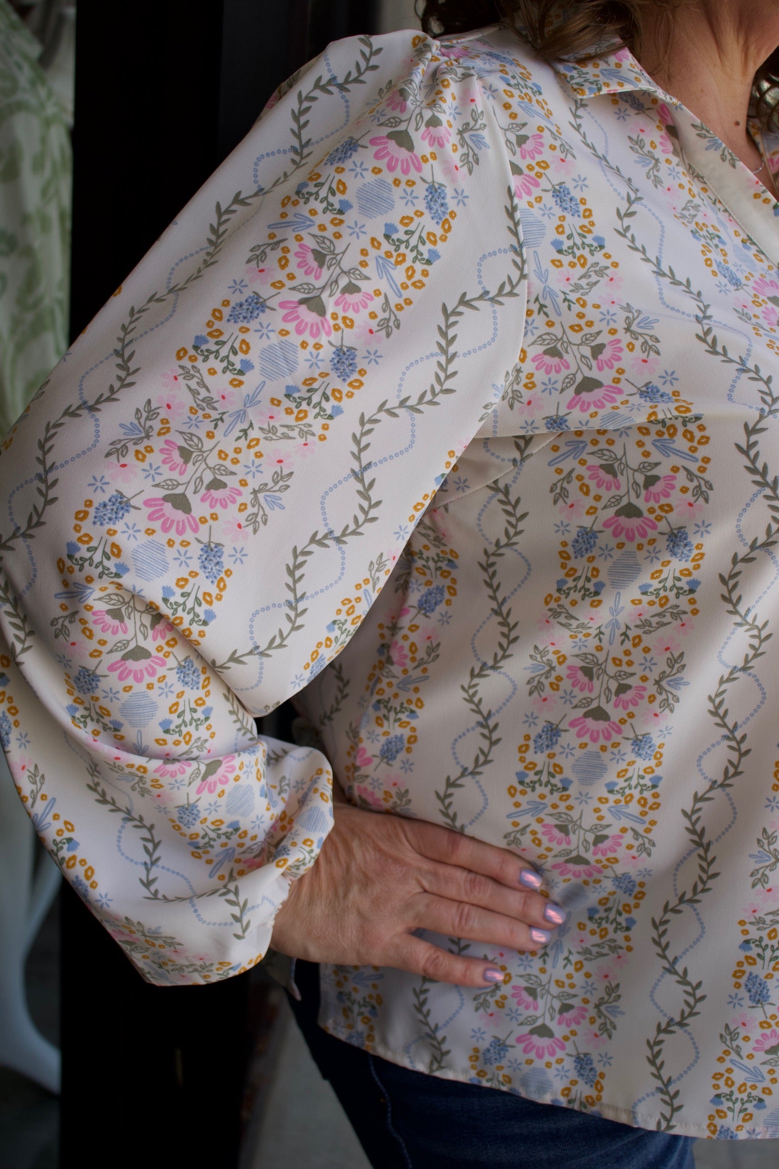 a floral patterned blouse with long sleeves.