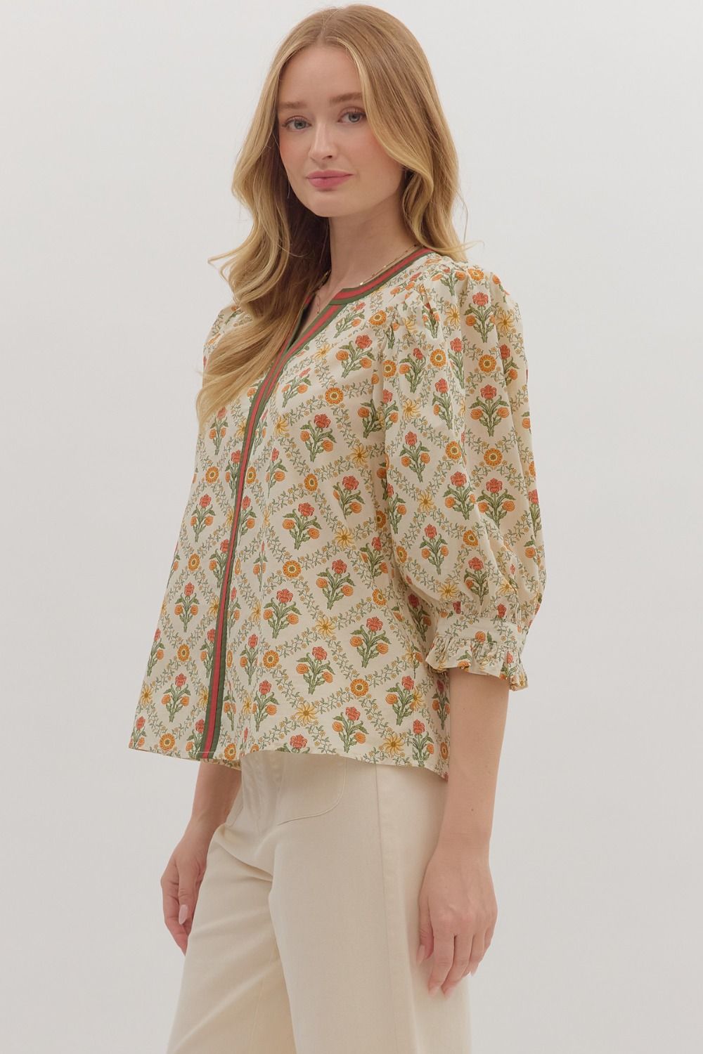 cream floral blouse with orange and green stripe down the middle