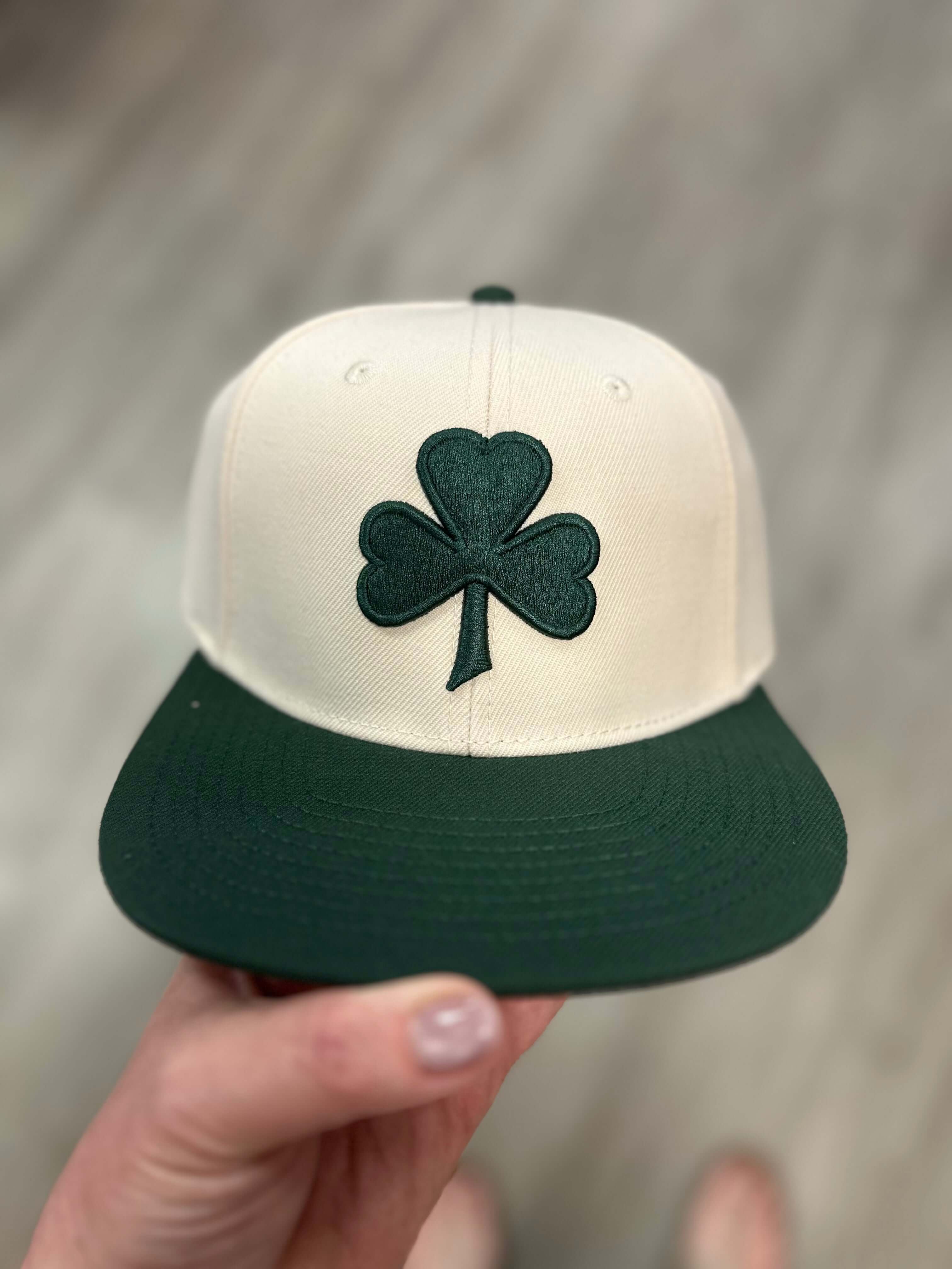 White baseball cap with green flat bill and green embroidered shamrock