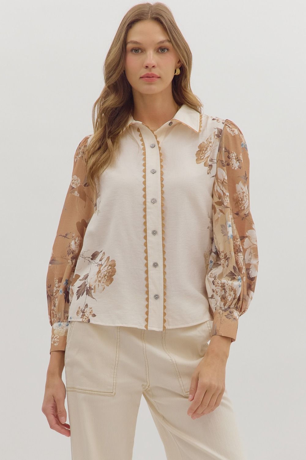 longsleeve cream blouse with warm toned floral patterns on the sleeves