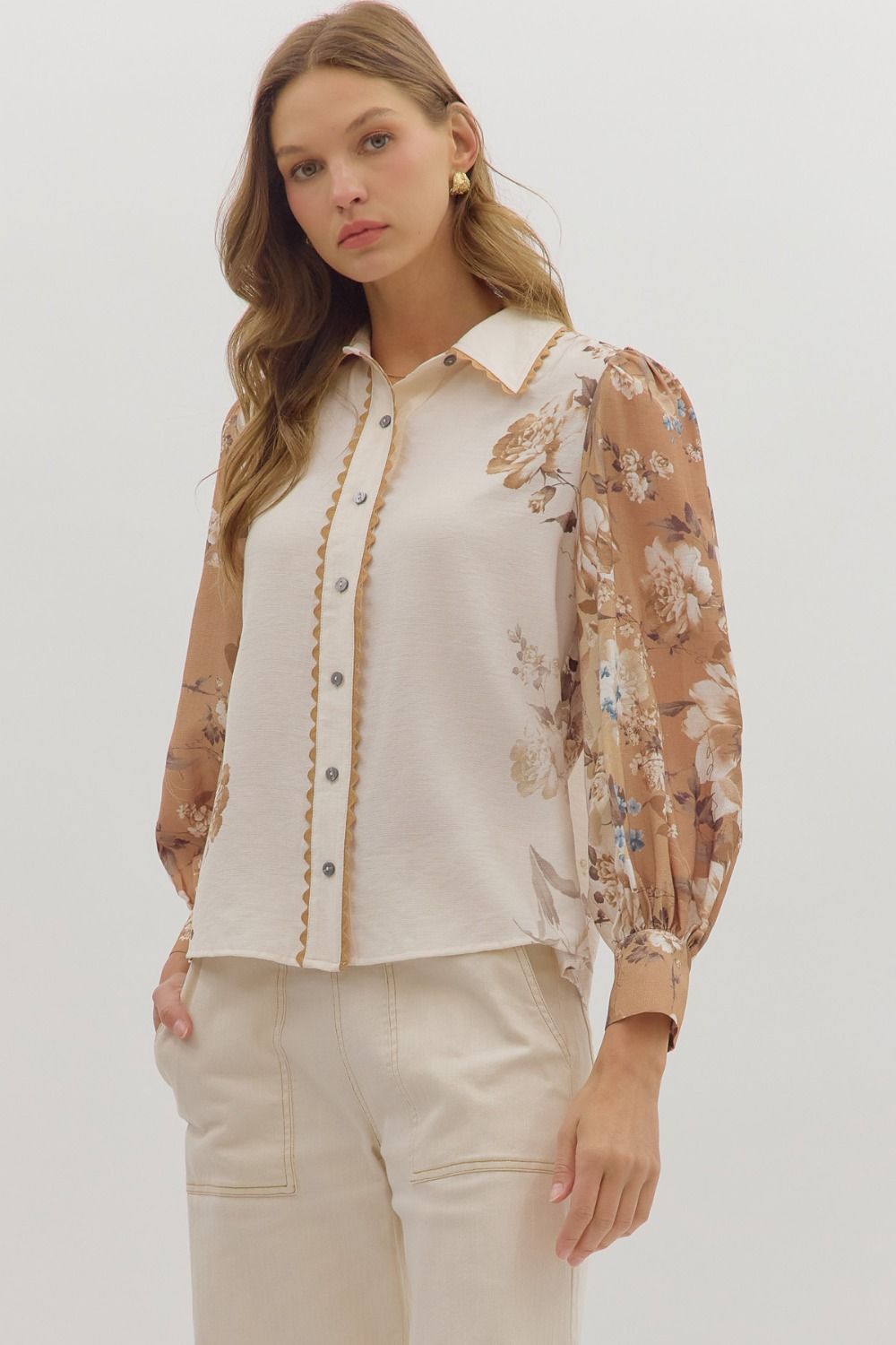 longsleeve cream blouse with warm toned floral patterns on the sleeves
