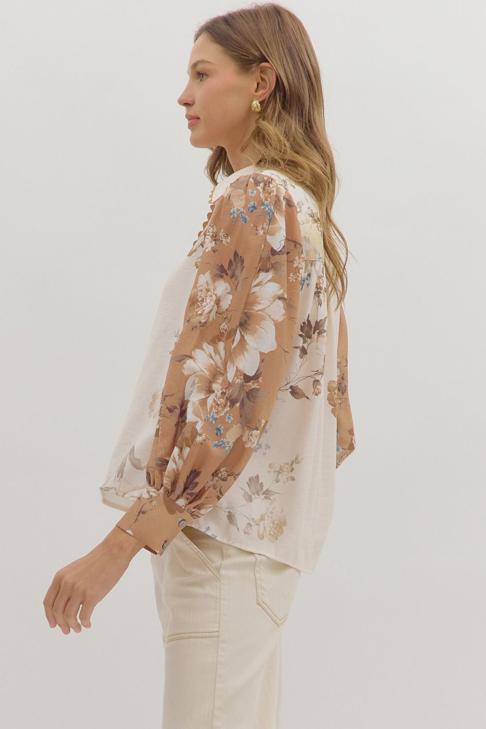 longsleeve cream blouse with warm toned floral patterns on the sleeves