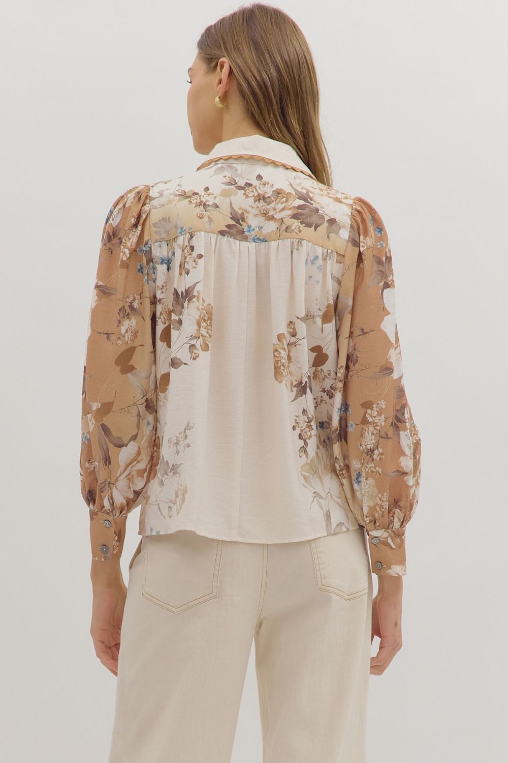 longsleeve cream blouse with warm toned floral patterns on the sleeves