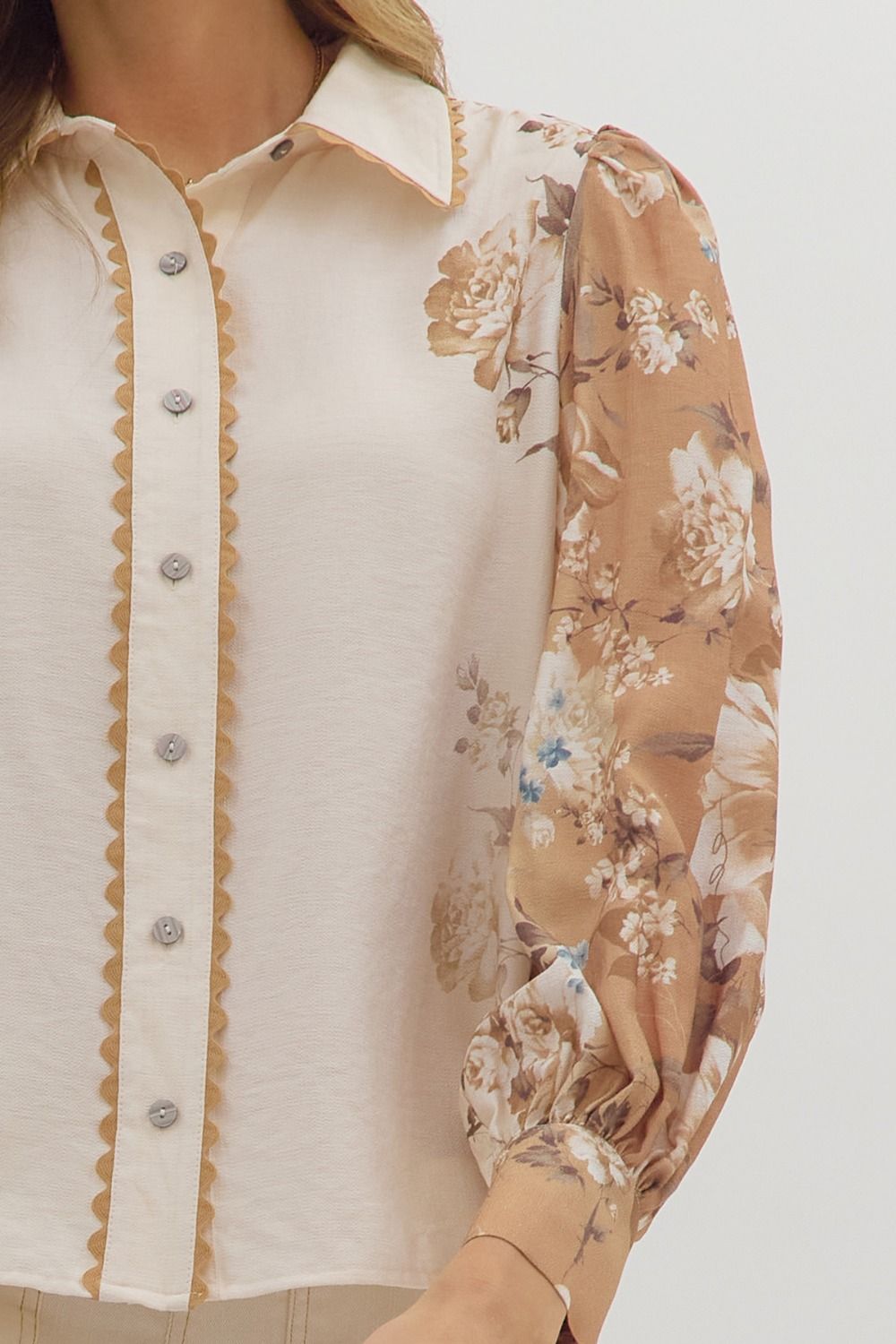 longsleeve cream blouse with warm toned floral patterns on the sleeves