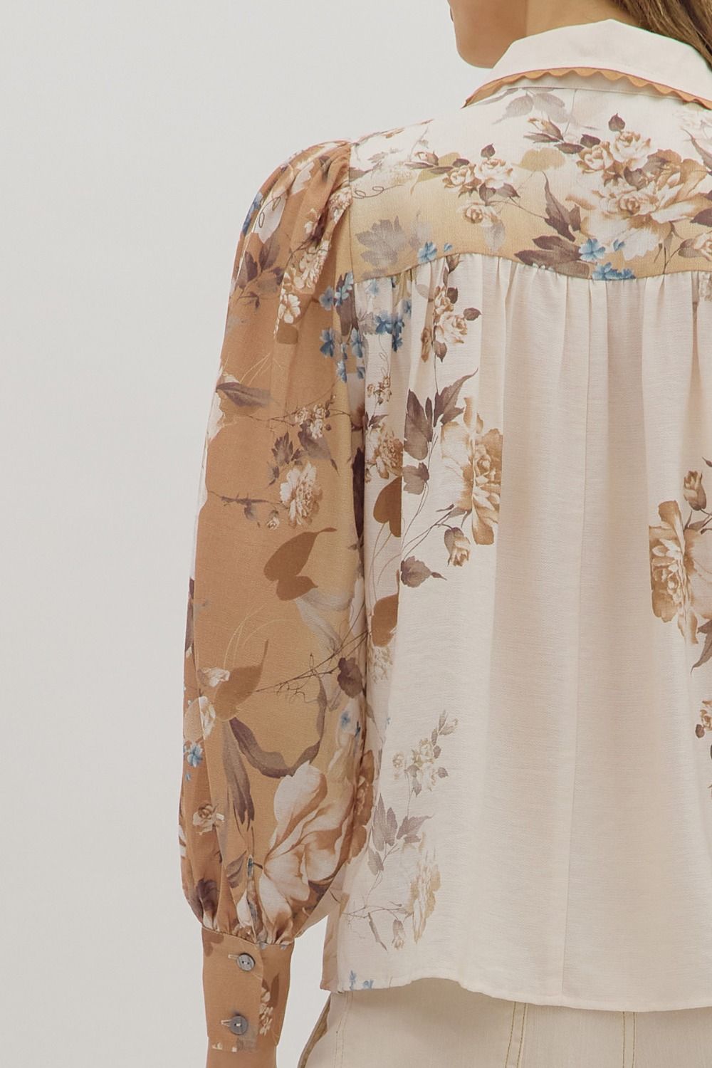 longsleeve cream blouse with warm toned floral patterns on the sleeves