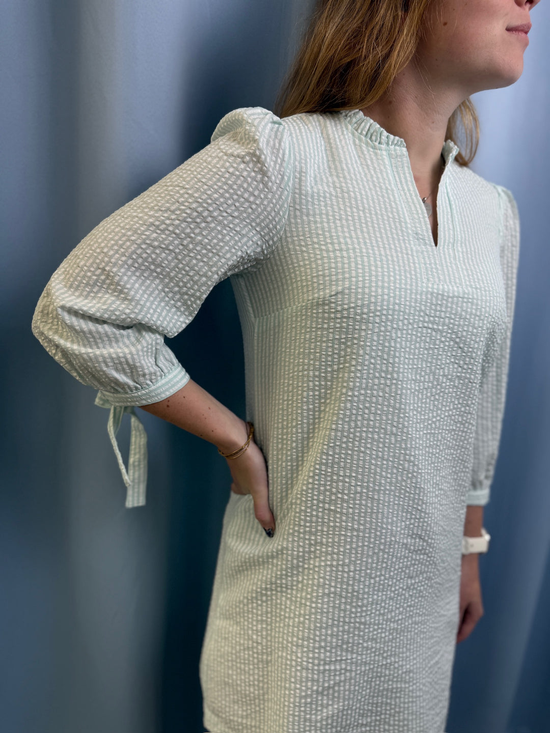 Woman wearing a textured white dress against a blue background