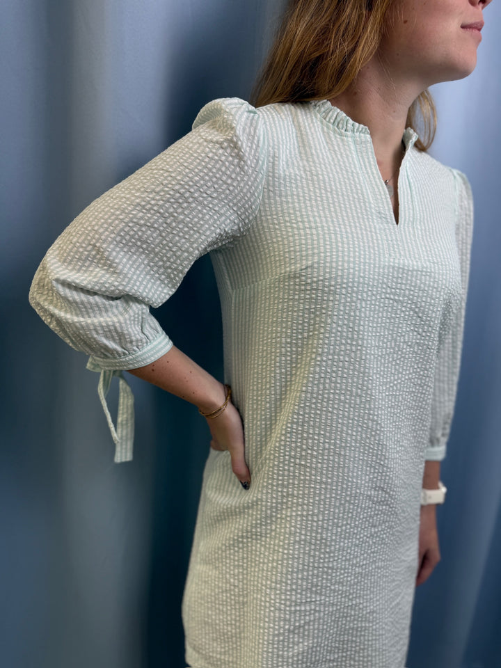 Woman wearing a textured white dress against a blue background