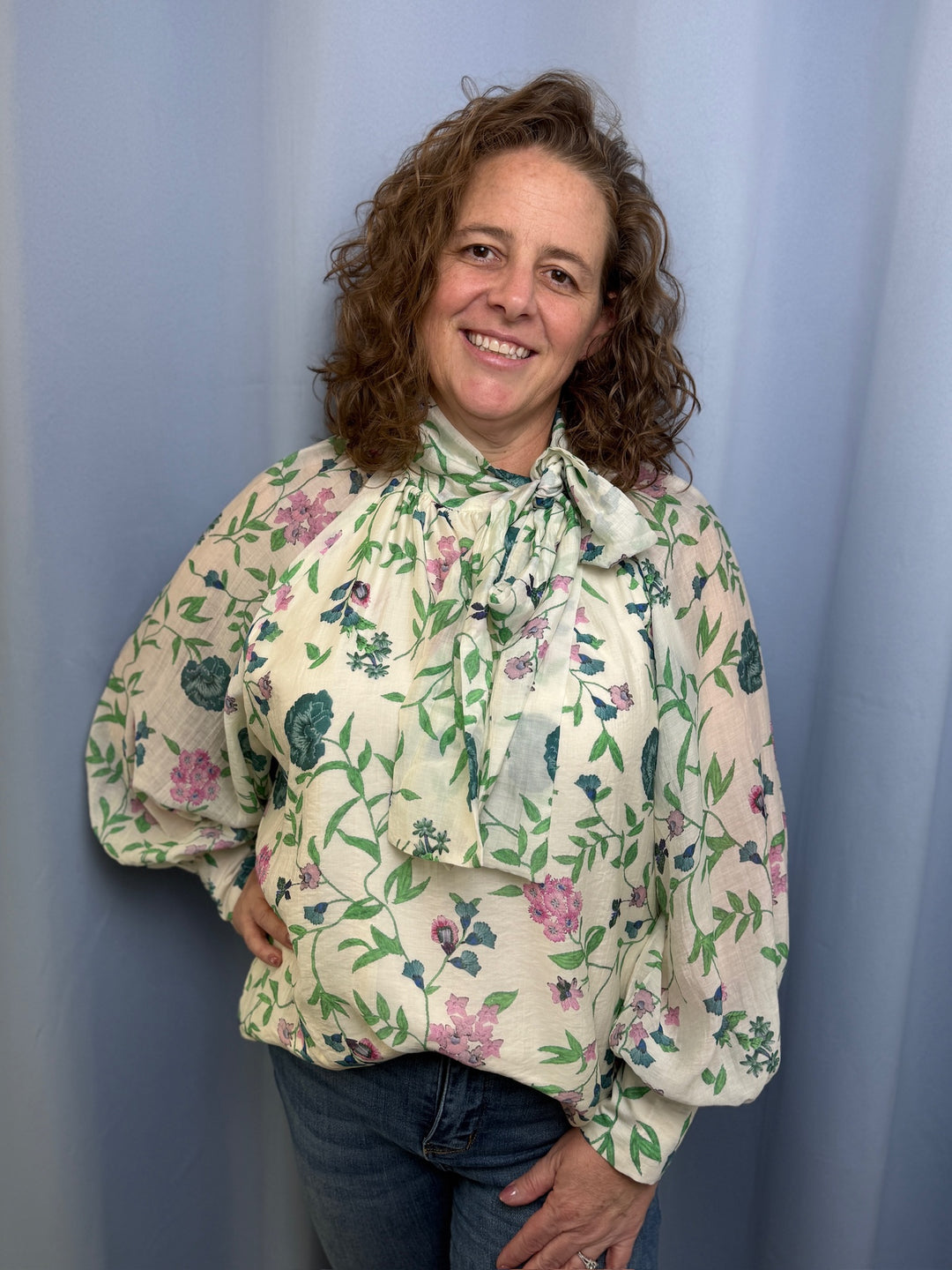 Woman wearing a floral blouse against a plain background