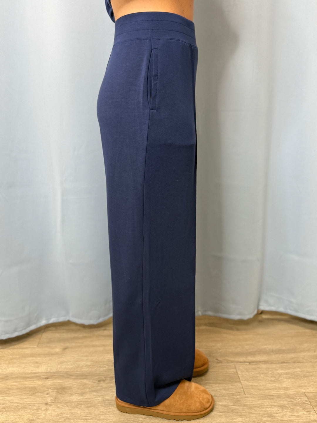 Navy blue pants worn by a person on a white background