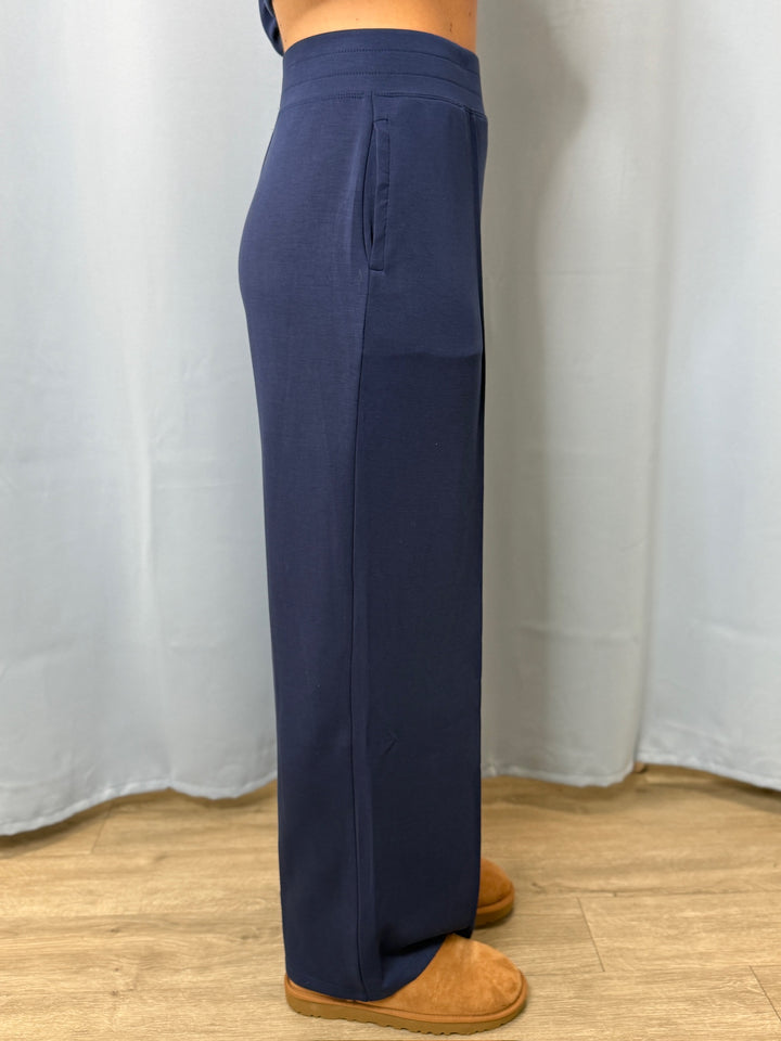 Navy blue pants worn by a person on a white background