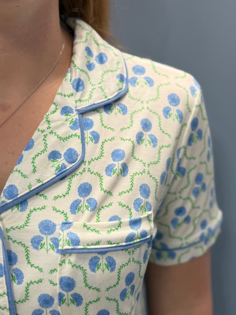 Close-up of a floral-patterned garment with blue and green details on a plain background