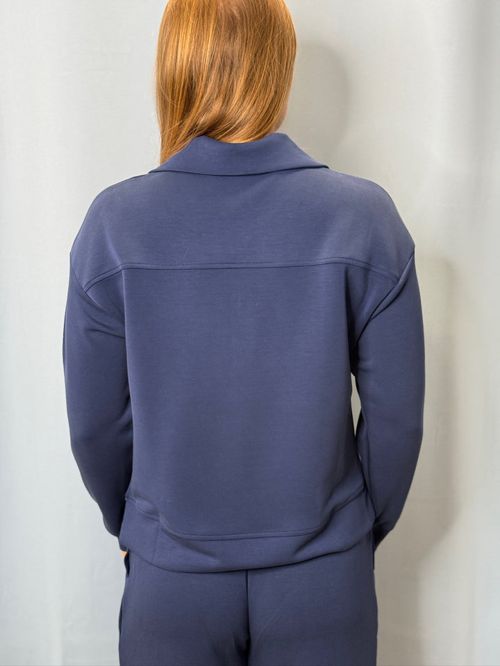 Person wearing a blue tracksuit against a plain background