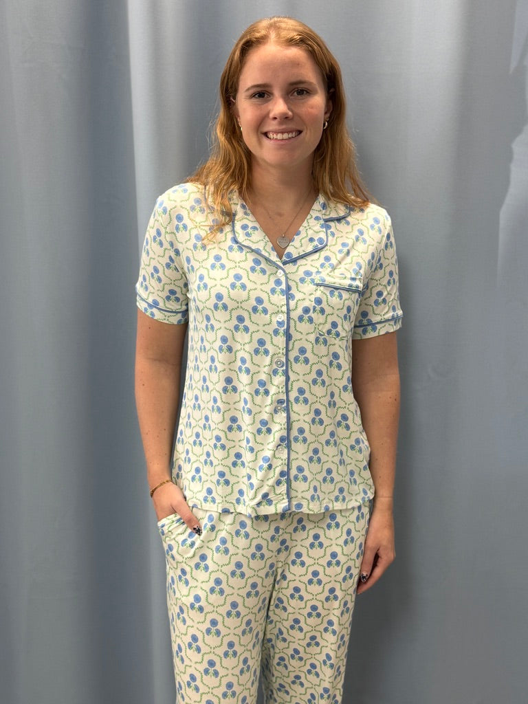 Woman wearing a floral pajama set against a gray background