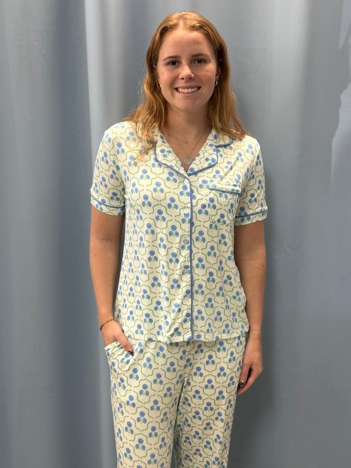 Woman wearing a floral pajama set against a gray background