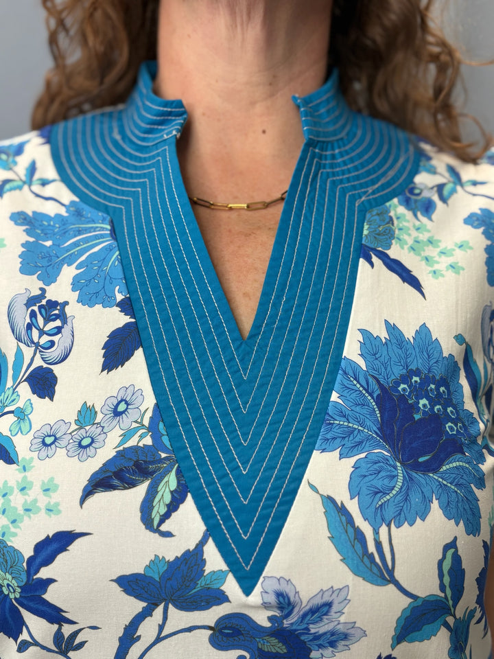 Close-up of a floral dress with a blue neckline and pattern.