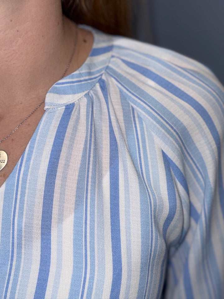 Close-up of a person wearing a blue and white striped shirt.