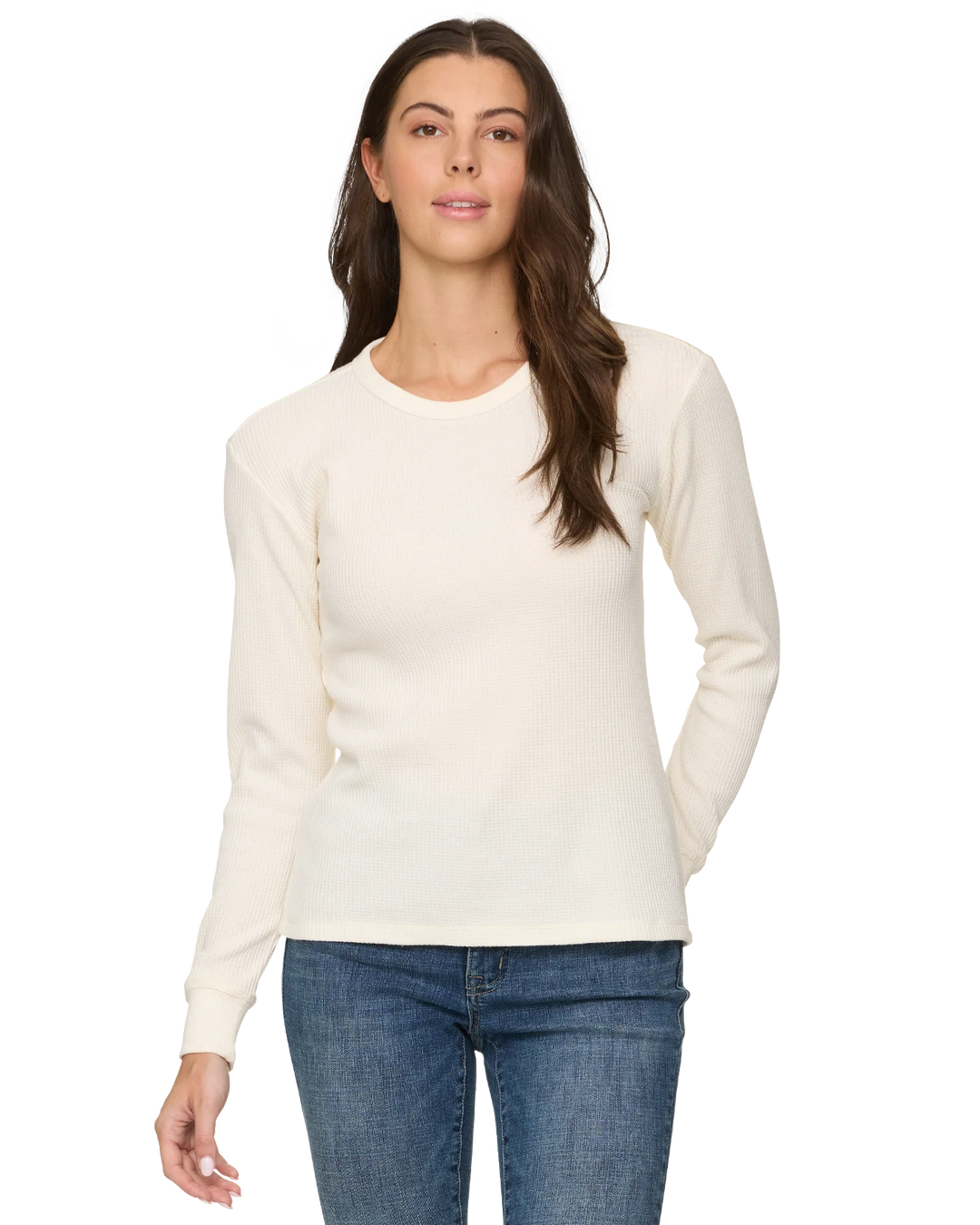Woman wearing a cream sweater and blue jeans on a white background