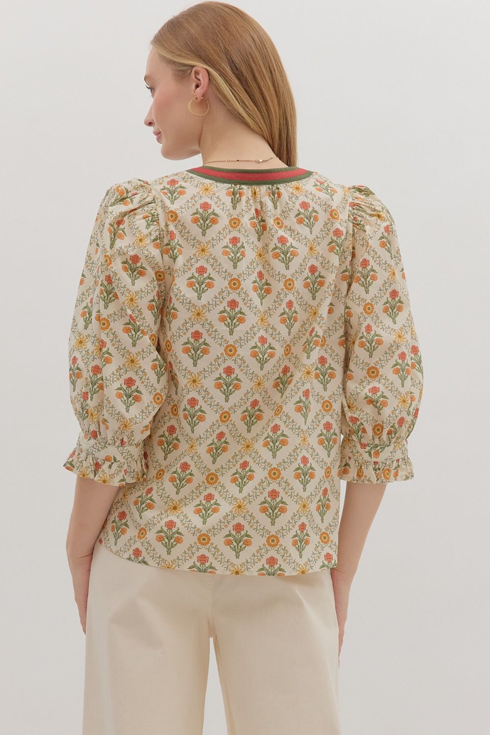 cream floral blouse with orange and green stripe down the middle 